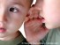 The boy whispering in an ear to the younger brother.